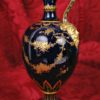 Jarra porcelana Royal Crown Derby con asa de máscara. Fondo azul y guirnaldas
