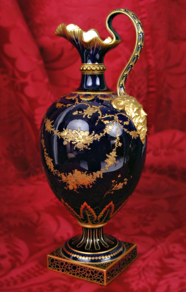 Jarra porcelana Royal Crown Derby con asa de máscara. Fondo azul y guirnaldas