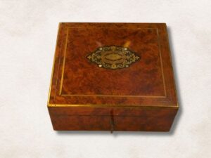 Caja cuadrada de nogal con incrustaciones de latón y madreperla .