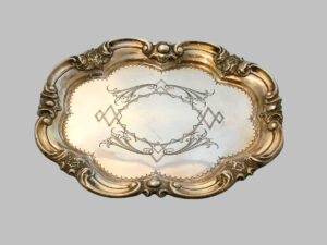 Bandeja de plata con bordes ondulados y cincelados, punteados en el centro.