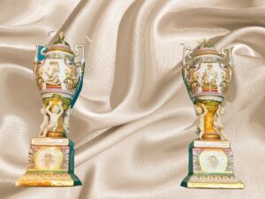 2 Jarrones de Porcelana de Sevres, bases con 3 niños sujetando la parte suoerior, con tapa de porcelana.