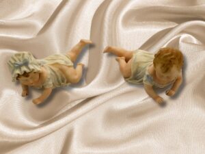 Pareja de niños de porcelana biscuit, gateando.
