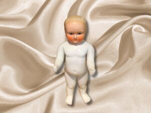 Muñeco Porcelana Congelada Charlie con pelo rubio y ojos verdes.